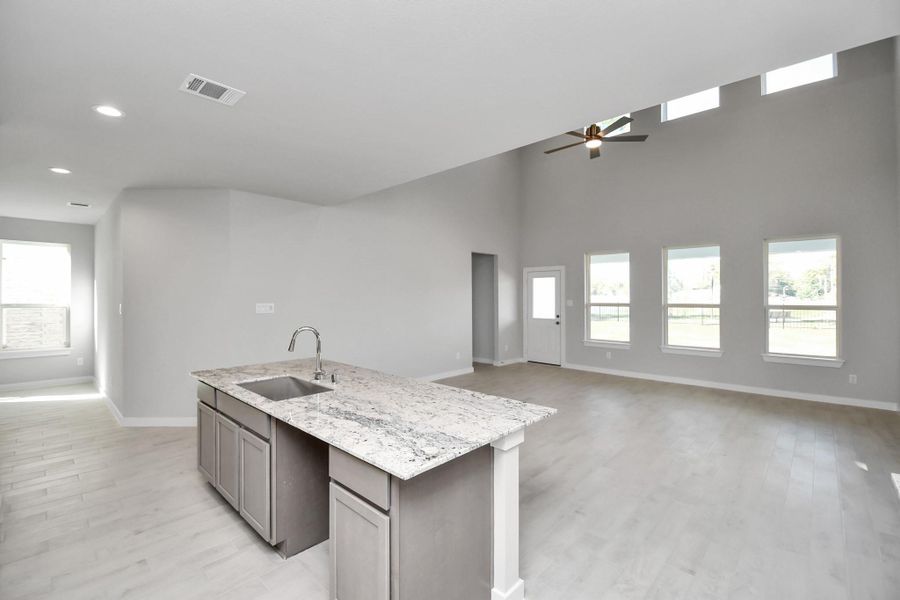 The open concept effortlessly connects the kitchen to the expansive family room, forming a perfect hub for gatherings. Sample photo of completed home with similar floor plan. Actual colors and selections may vary.