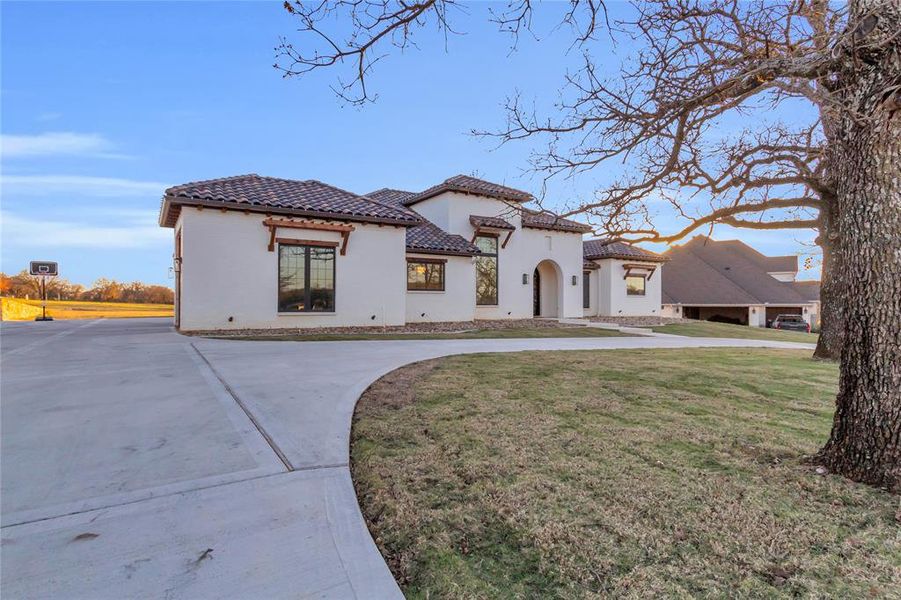 Mediterranean / spanish-style house featuring circled driveway