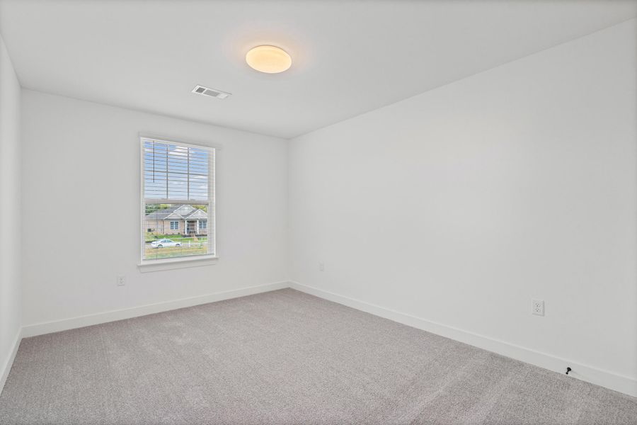 Neutral gray carpeting, white walls, and a single window with blinds Neutral gray carpeting, white walls, and a single window with blinds