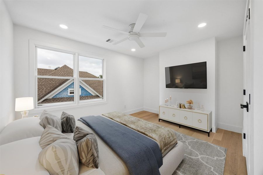 Large windows, clean architectural lines, and engineered wood flooring create a bright secondary bedroom with a calm and functional layout. Positioned on the upper level, the room offers flexibility for guests, workspace needs, or long-term everyday use. (digitally staged)