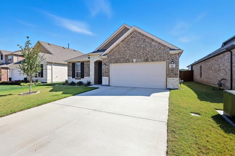View of front facade with driveway, brick siding, and an attached garage View of front facade with driveway, brick siding, and an attached garage