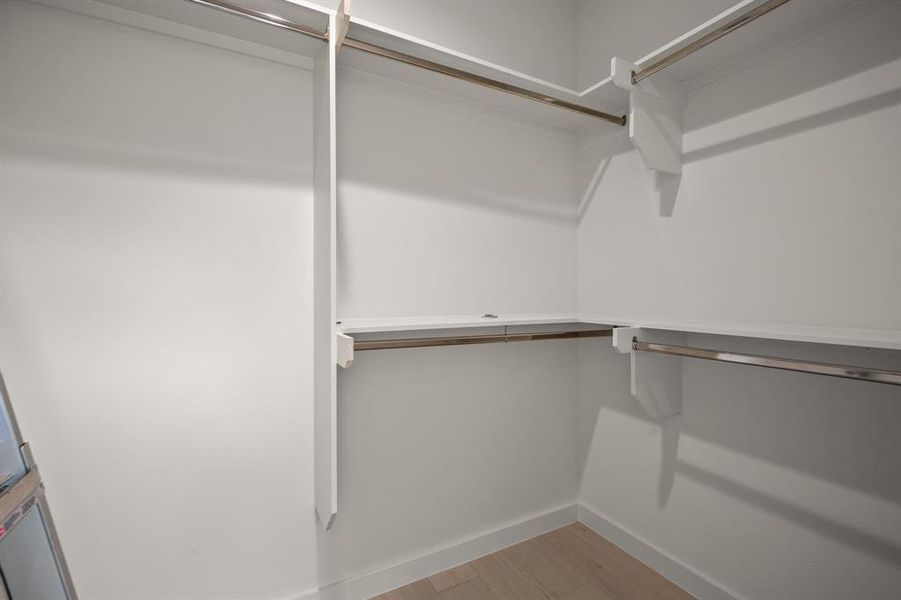 Walk in closet with light wood-style floors