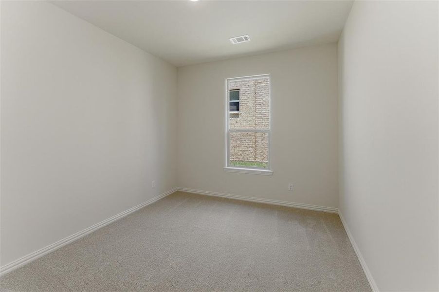 Room featuring light neutral wall tones, clean baseboards, and soft-toned carpeting