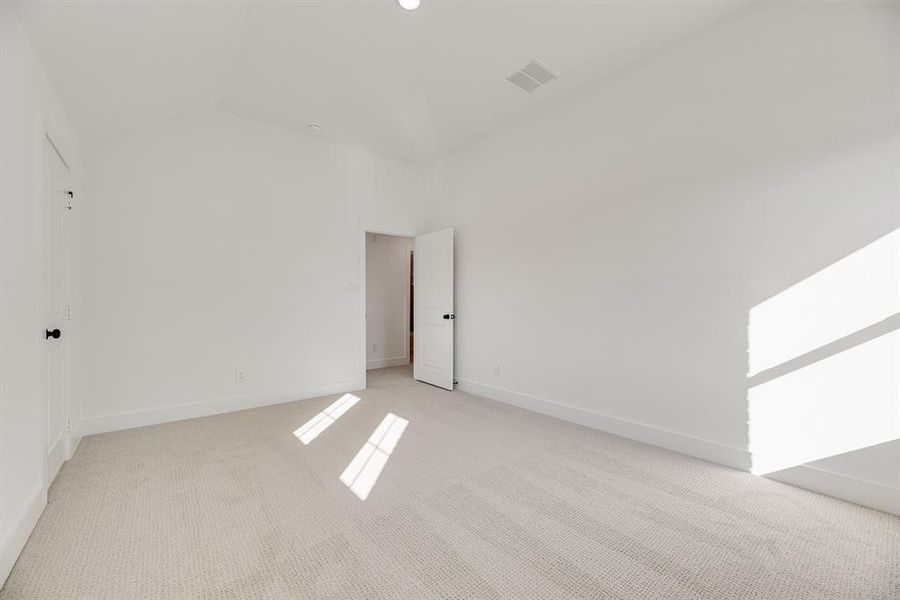 Empty room with carpet flooring and lofted ceiling