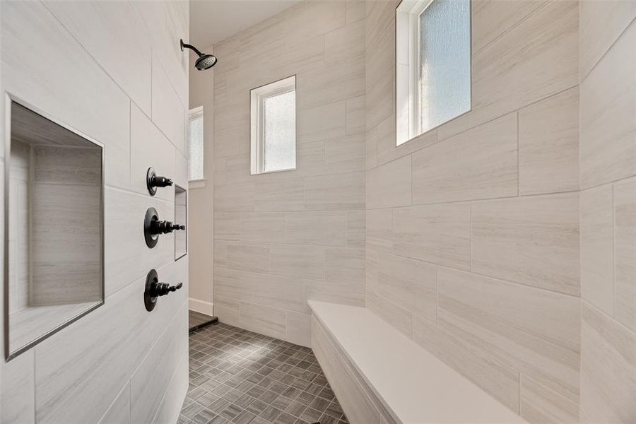 Full bath with tiled shower and tile walls