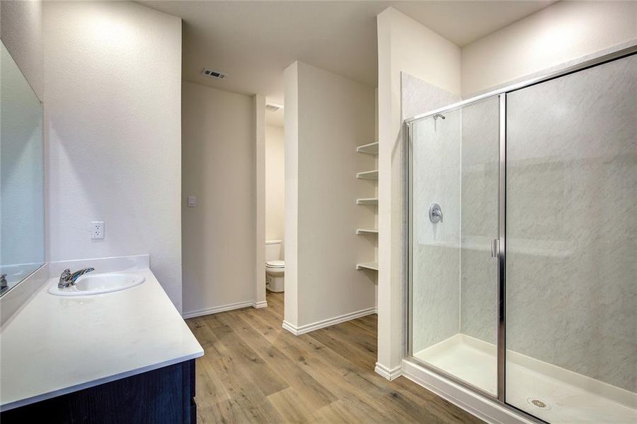 Full bath featuring vanity, a shower stall, and light wood-style flooring