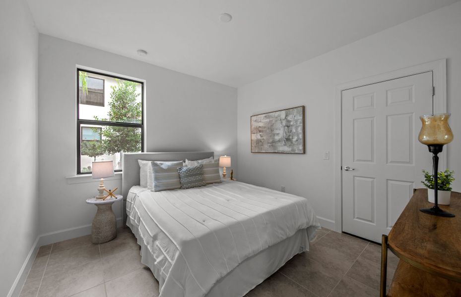 Secondary bedroom with large window and closet