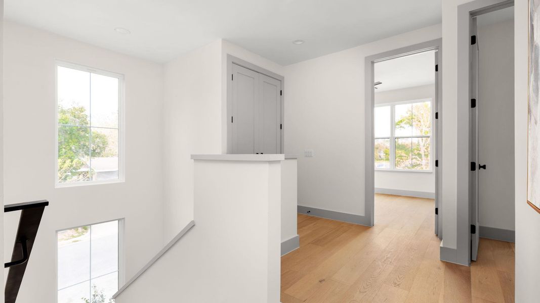 Hall with an upstairs landing and light wood-type flooring