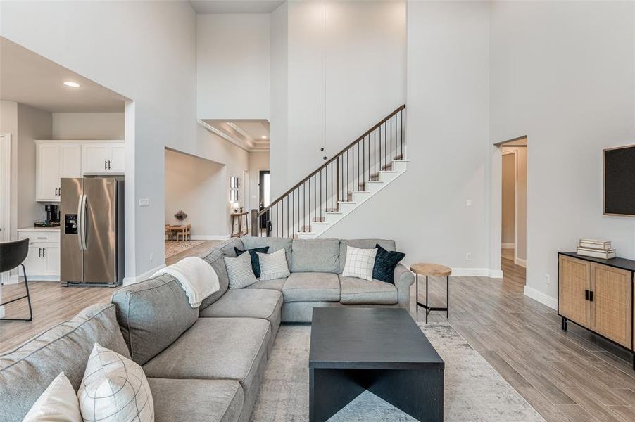 Living room featuring light hardwood / wood-style floors and a high ceiling