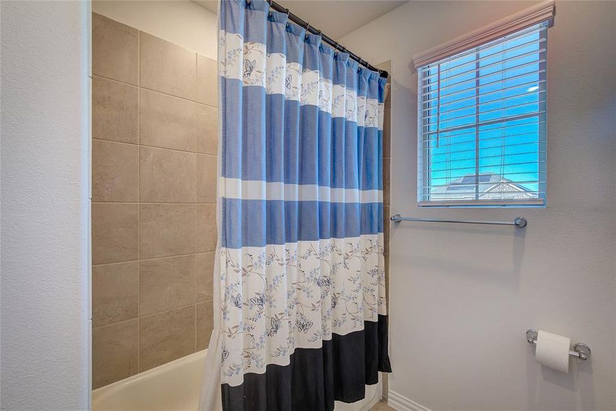 Bathroom with shower / bath combo and a healthy amount of sunlight