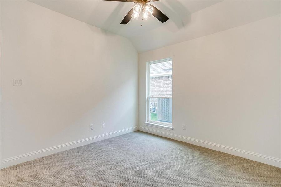 Unfurnished room with light colored carpet, vaulted ceiling, and ceiling fan