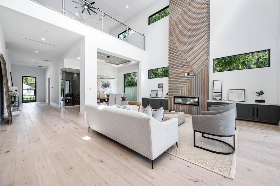 Spacious living area with soaring 23-foot ceilings and an open upstairs loft overlooking the space, creating an airy and grand atmosphere.