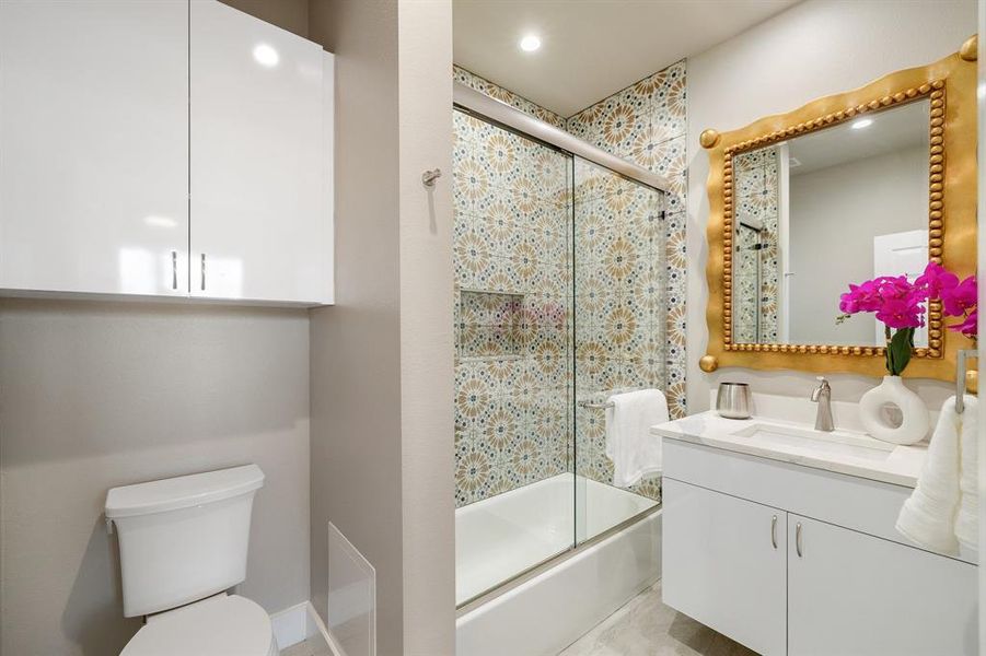 Full bathroom featuring toilet, combined bath / shower with glass door, and vanity