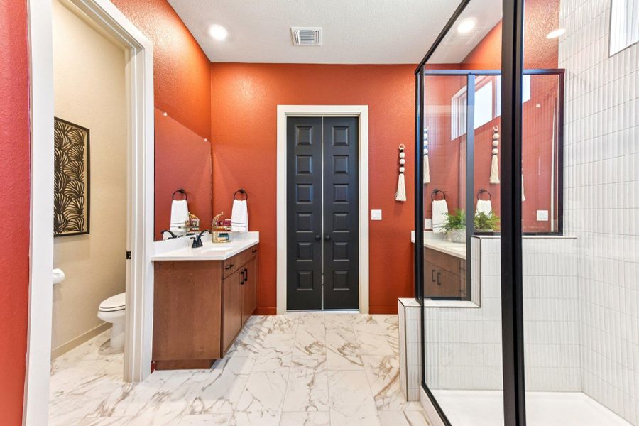 Marble-look tile flooring flows through this bright, functional bathroom featuring a spacious glass-enclosed shower. Marble-look tile flooring flows through this bright, functional bathroom featuring a spacious glass-enclosed shower.