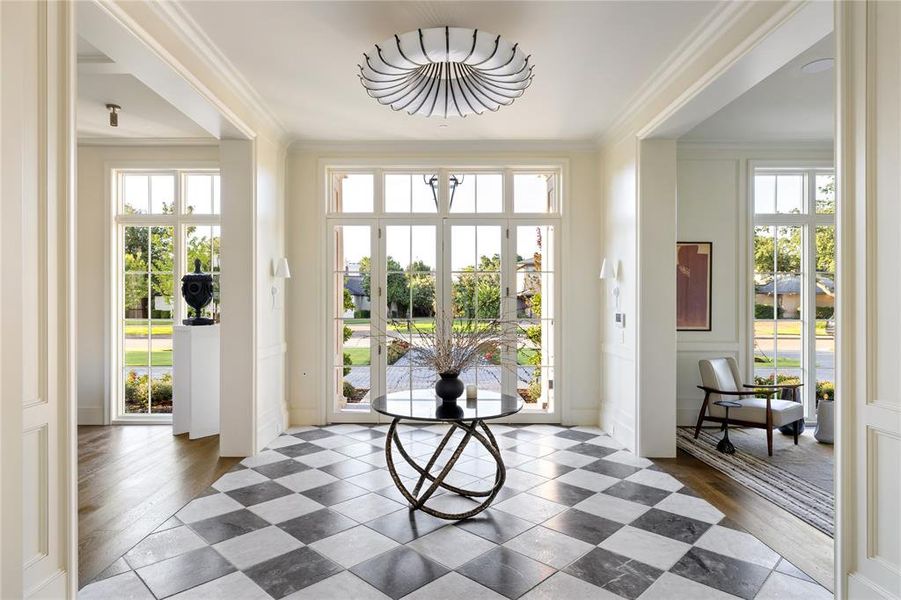 Doorway to outside featuring crown molding and tile patterned flooring Doorway to outside featuring crown molding and tile patterned flooring