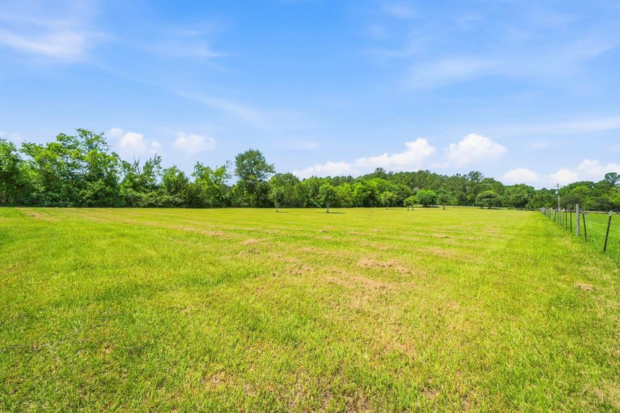 Partially fenced acreage to the right is also a part of the 4.92 acre parcel extending to the tree line.