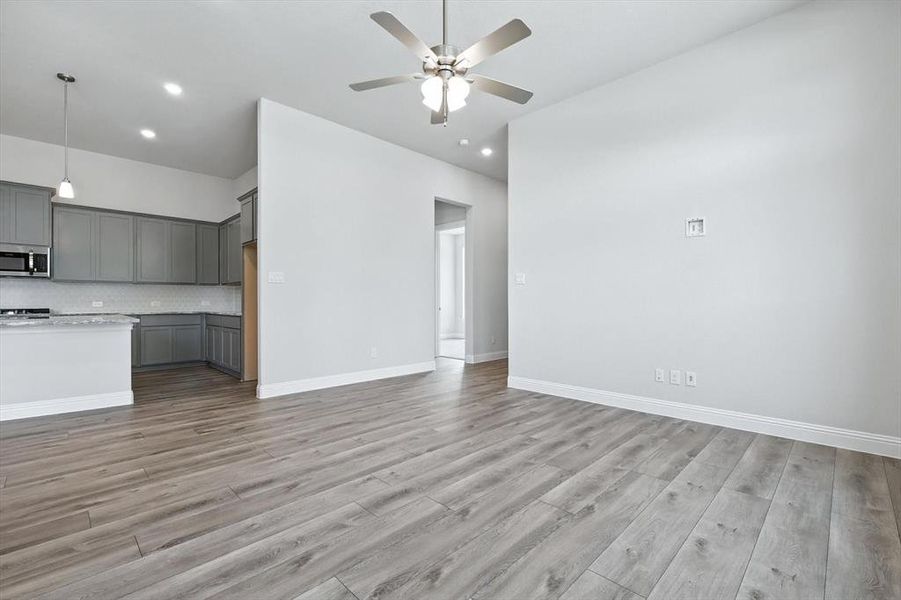 Unfurnished living room with a ceiling fan, light wood-style flooring, and recessed lighting Unfurnished living room with a ceiling fan, light wood-style flooring, and recessed lighting