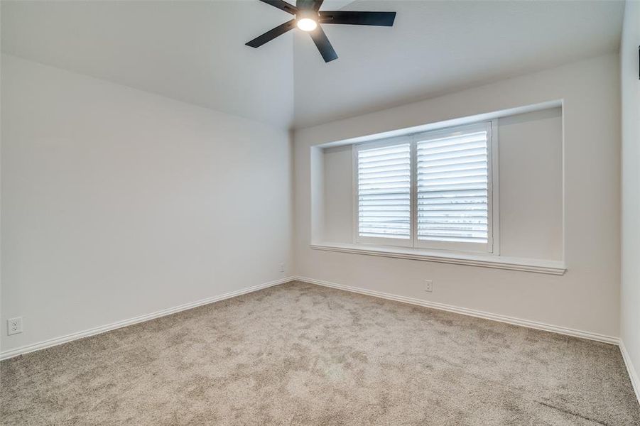 Upstairs room for added living or play area, with light carpet, ceiling fan, and lofted ceiling