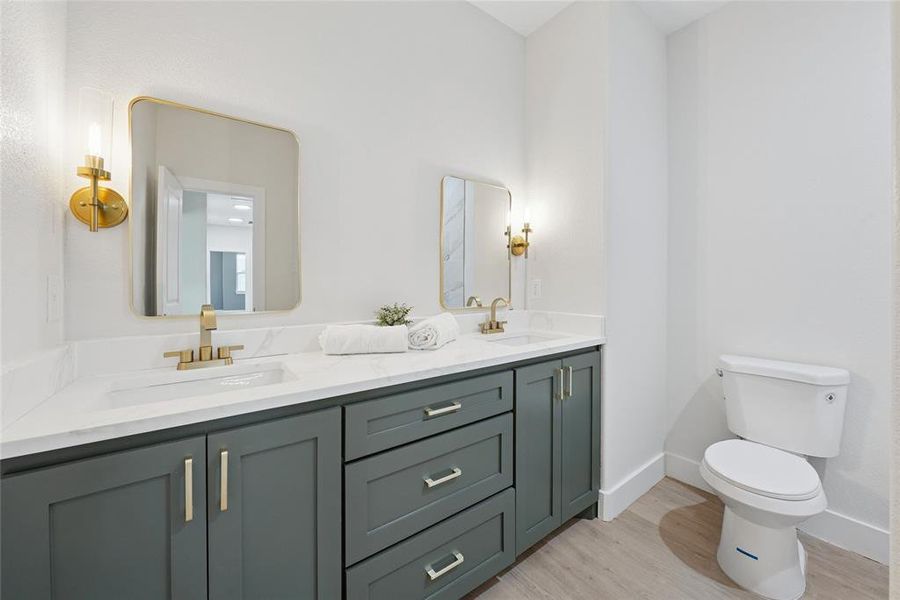 Bathroom featuring light wood-type flooring and double vanity Bathroom featuring light wood-type flooring and double vanity