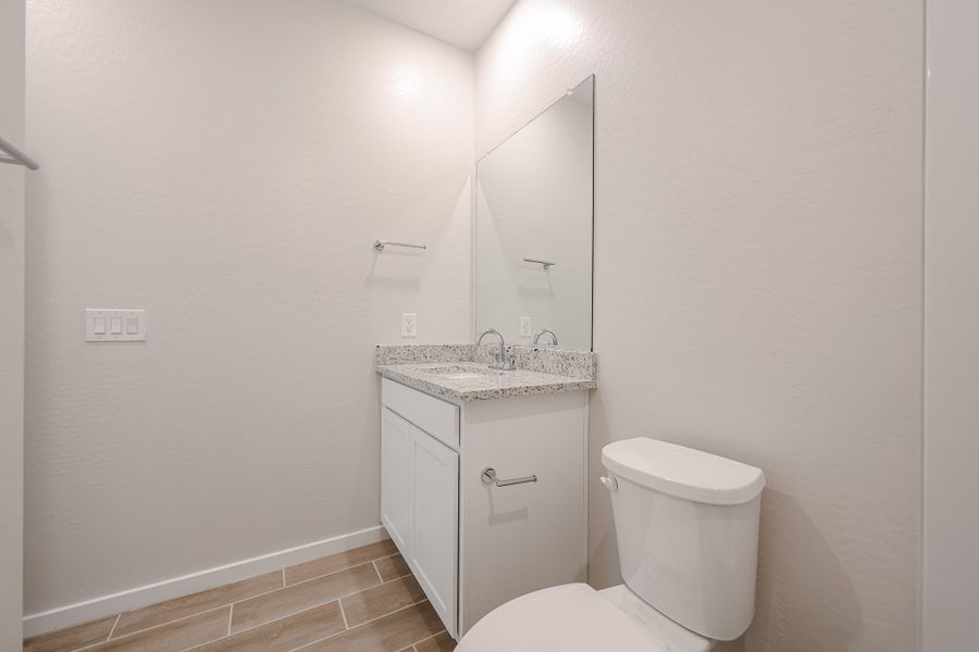 A bathroom with a sink toilet and mirror. A bathroom with a sink toilet and mirror.
