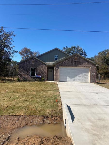 Ranch-style home featuring brick siding, a front lawn, concrete driveway, a garage, and board and batten siding Ranch-style home featuring brick siding, a front lawn, concrete driveway, a garage, and board and batten siding