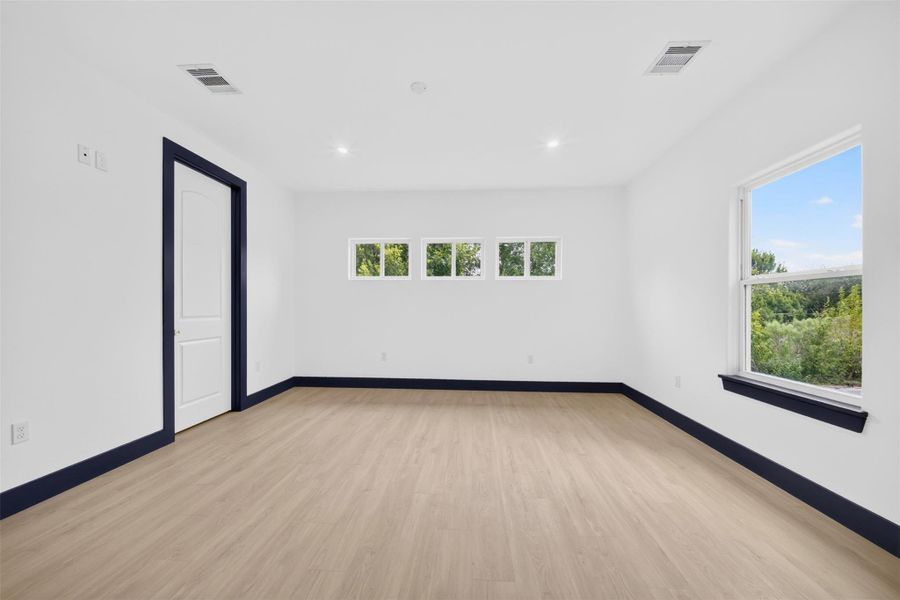 Spacious bedroom with multiple windows providing abundant natural light