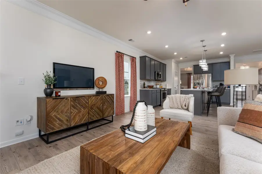 The Palmer- Family Room into the Kitchen. The sample image is a staged model, to be used for illustrative purposes only. Upgrades, options, and colors will vary.
