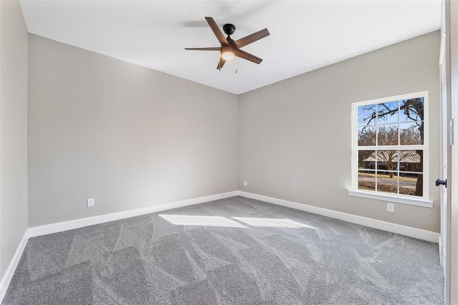 Carpeted spare room with ceiling fan