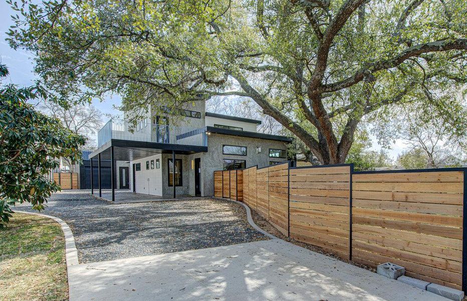 View of front facade with stone siding, a patio area, and fence