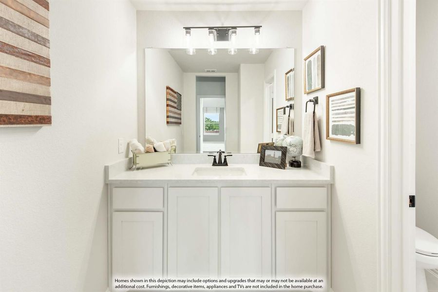 Bathroom vanity with white cabinets, single sink, large mirror, and track lighting above