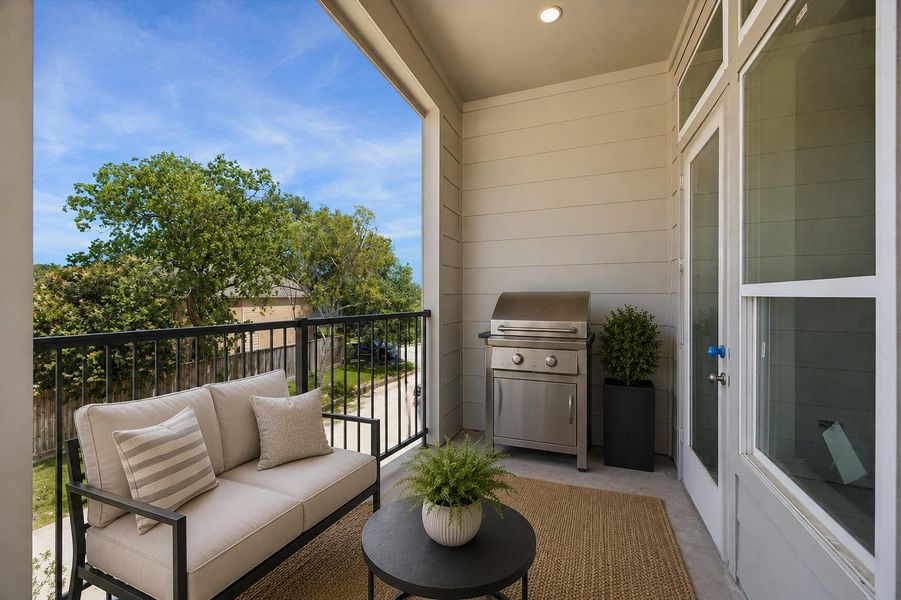 Covered terrace complete with outdoor grilling area and cozy seating—perfect for entertaining year-round. A digitally staged image.