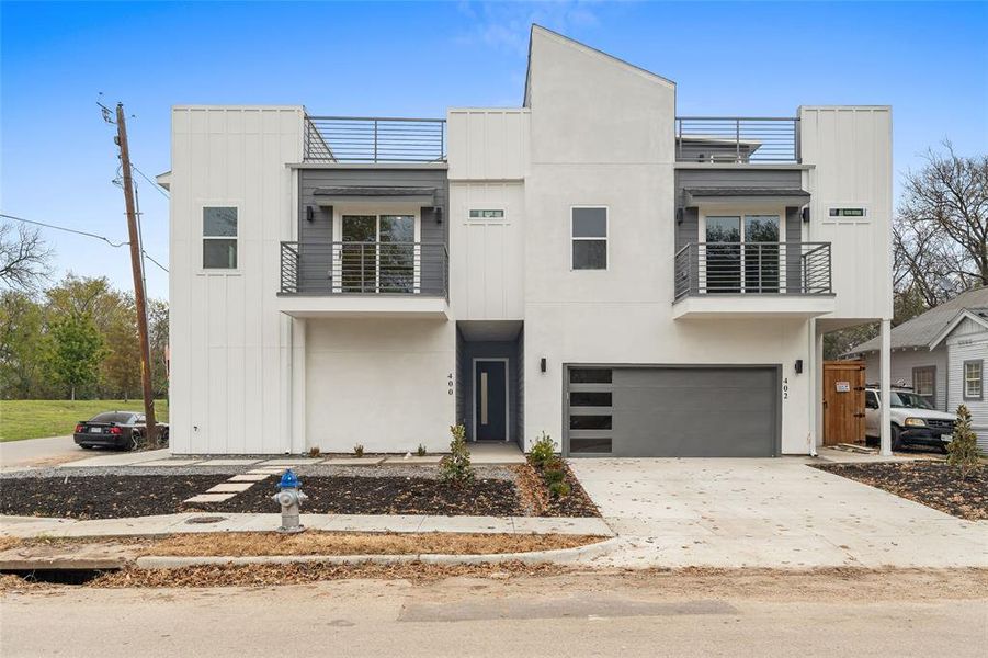 Contemporary house with a balcony, driveway, a garage, and board and batten siding Contemporary house with a balcony, driveway, a garage, and board and batten siding