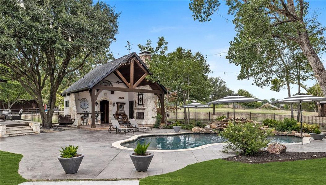 View of swimming pool with a gazebo, a patio area, and an outdoor fireplace