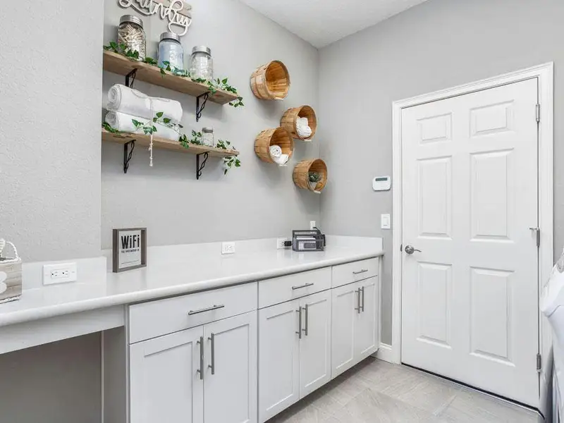 At the garage entry, the spacious laundry room and convenient drop zone keep daily life organized - Waylyn by Highland Homes