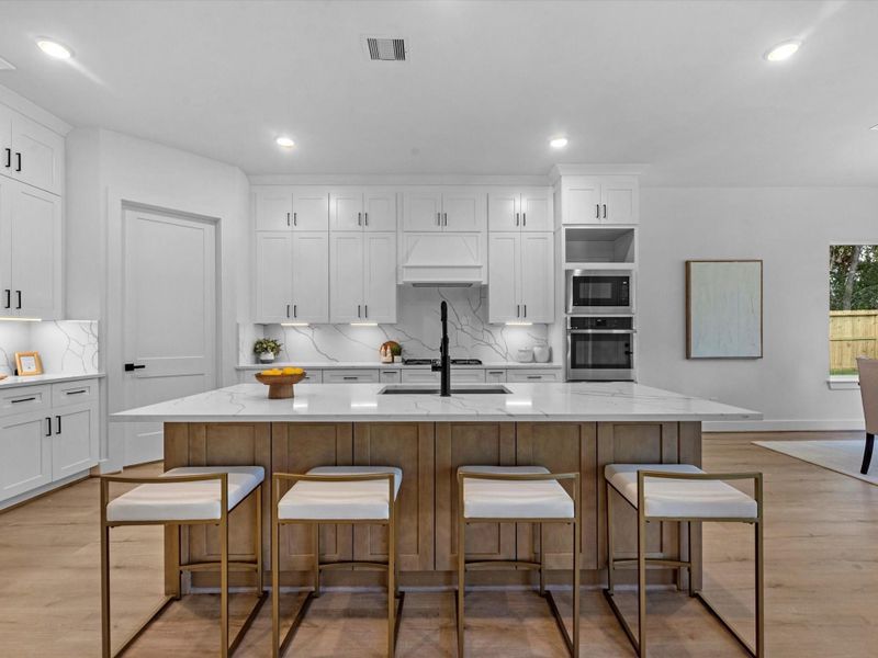 Large island kitchen w/ a carefully chosen selection coordination that brings a warm but contemporary design to this functional space