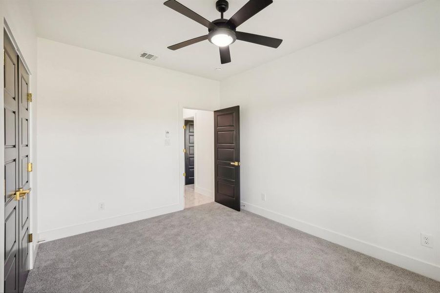 Unfurnished bedroom featuring ceiling fan and light colored carpet