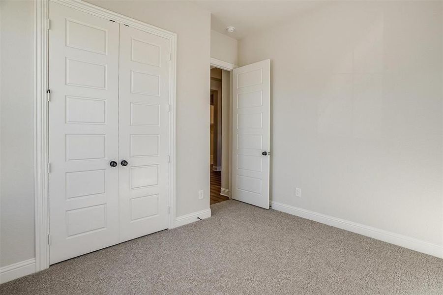 Unfurnished bedroom featuring a closet and carpet floors