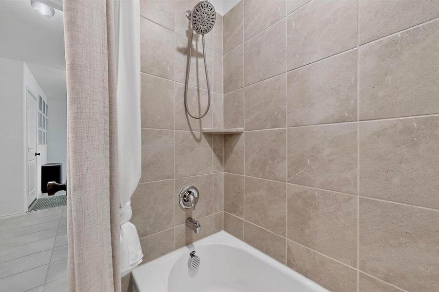 Full bath featuring shower / bath combo and tile patterned floors Full bath featuring shower / bath combo and tile patterned floors