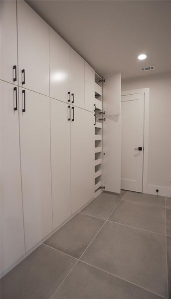 Mudroom wall-to-wall drawer storage. 1/2 bath beyond for total privacy. Bench to remove shoes from garage and catch-all space above. Coat closet with more storage and drawers.