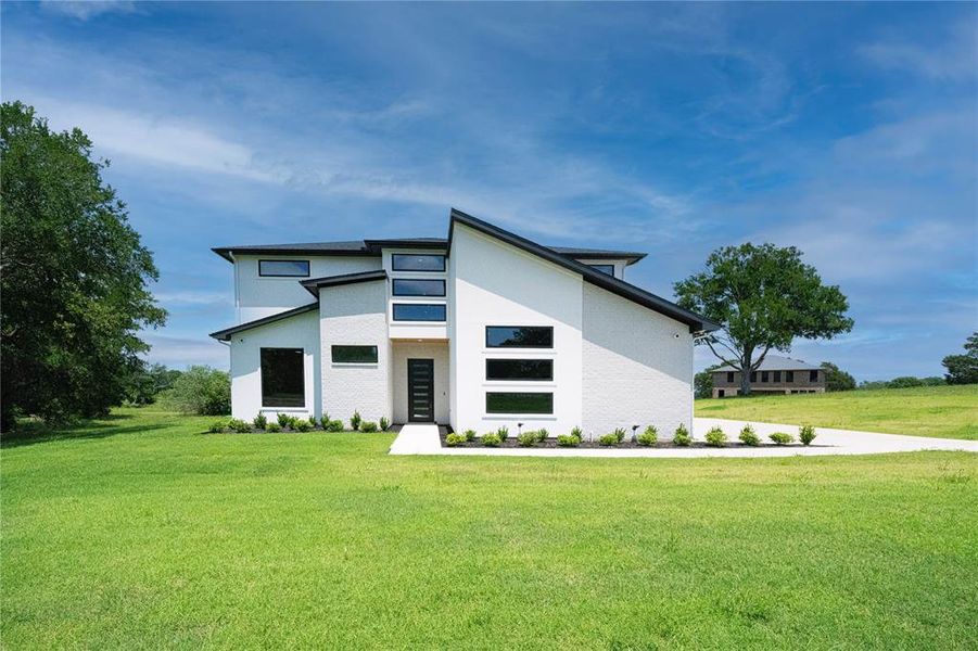View of front of house featuring a front yard and stucco siding View of front of house featuring a front yard and stucco siding