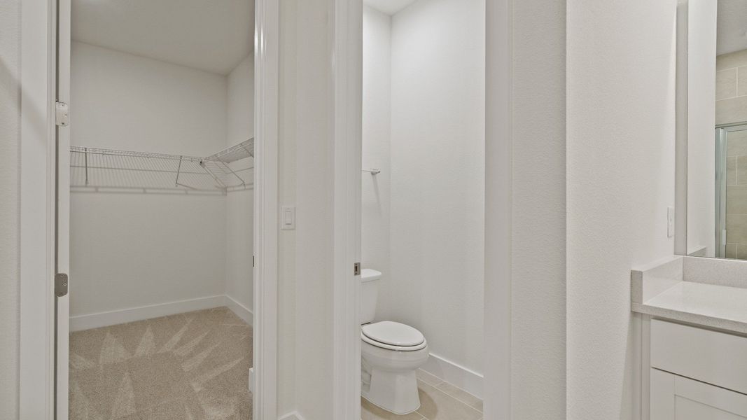 Primary walk-in closet and water closet in the Buttonwood floorplan by DRB Homes at Lakeside at Satilla in Saint Cloud, FL