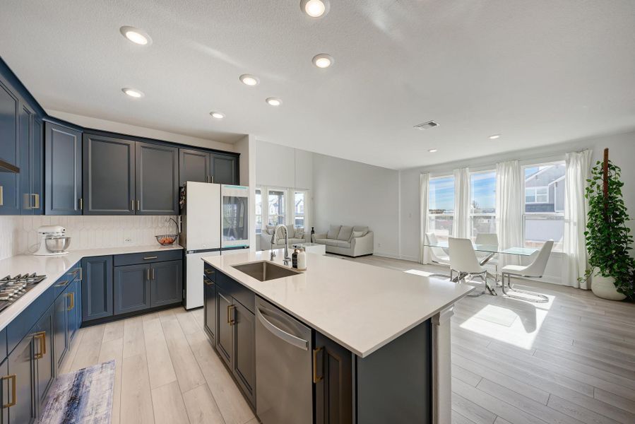 Kitchen featuring stainless steel appliances, light stone countertops, light wood finished floors, backsplash, and recessed lighting