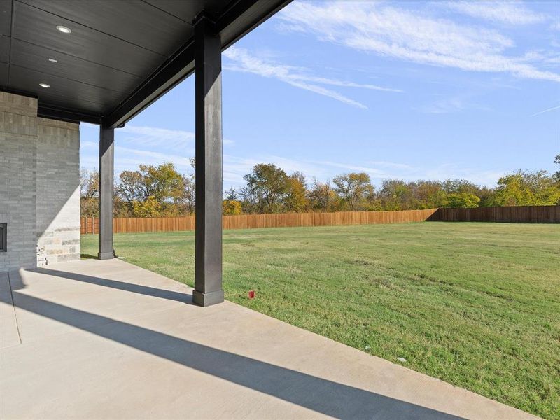 Fenced backyard with a patio area Fenced backyard with a patio area