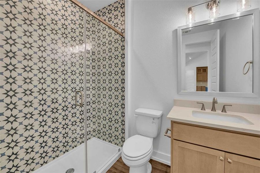 Bathroom featuring vanity, a shower stall, and toilet
