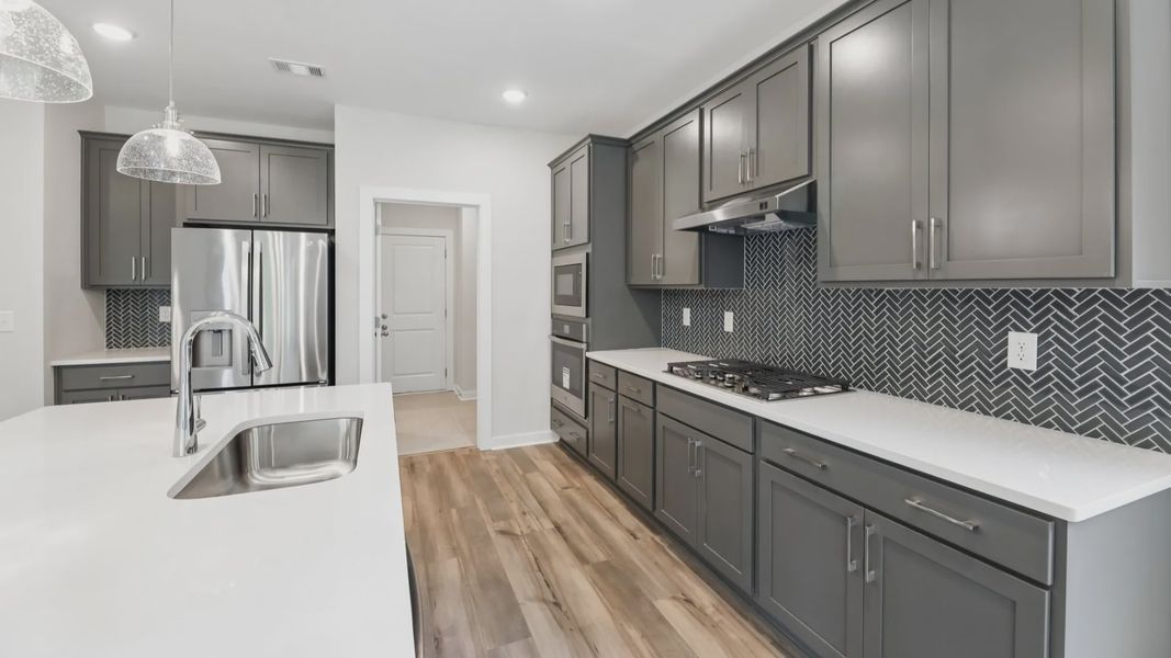 Kitchen with quarts countertops, pendant lighting, and hard surface flooring