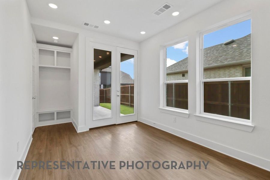 The dining area, situated next to the kitchen, features bright windows and a back door to the patio, offering a seamless space for meals and outdoor access.