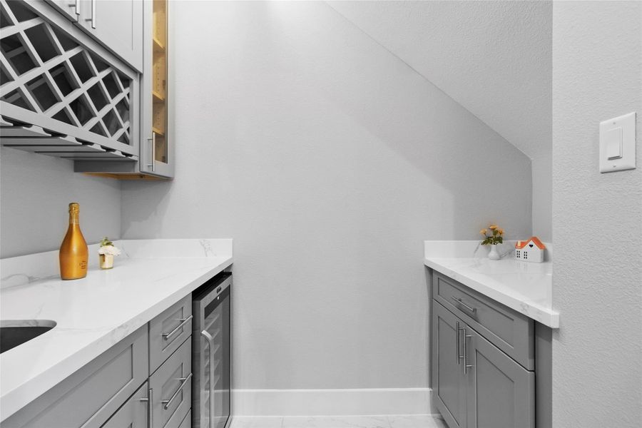 This tucked-away beverage station is the kind of detail you didn’t know you needed until it’s yours—custom cabinetry, dedicated wine storage, and a built-in fridge that makes hosting feel seamless. It’s perfectly positioned for entertaining without interrupting the flow of the main living space. This tucked-away beverage station is the kind of detail you didn’t know you needed until it’s yours—custom cabinetry, dedicated wine storage, and a built-in fridge that makes hosting feel seamless. It’s perfectly positioned for entertaining without interrupting the flow of the main living space.