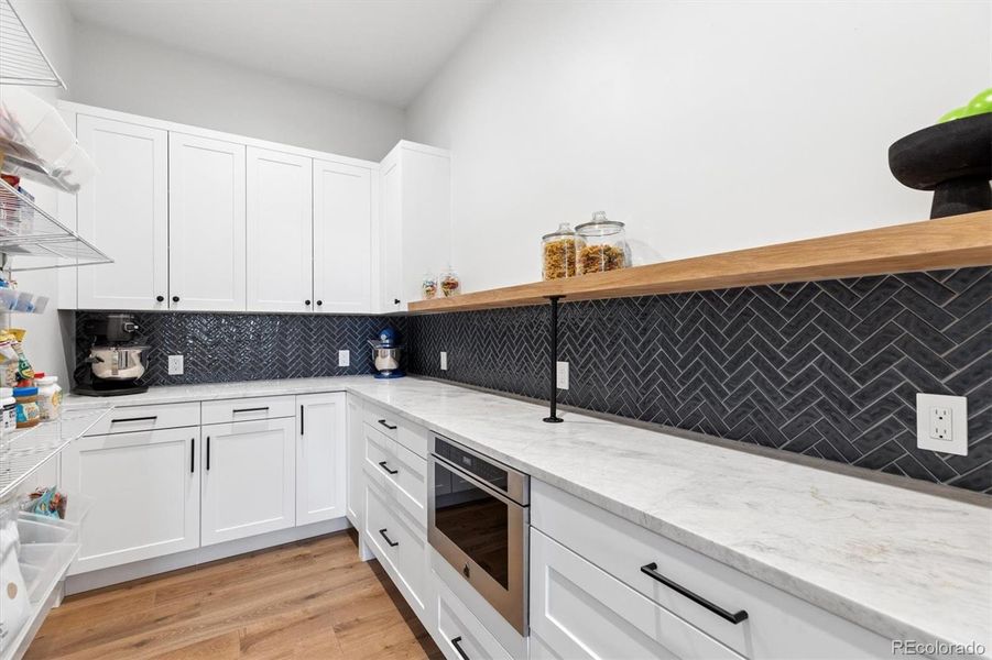 Hidden pantry with Matterhorn Dolomite countertops, herringbone tile, built-in microwave and amazing storage wall complete with built in baskets and racks Hidden pantry with Matterhorn Dolomite countertops, herringbone tile, built-in microwave and amazing storage wall complete with built in baskets and racks