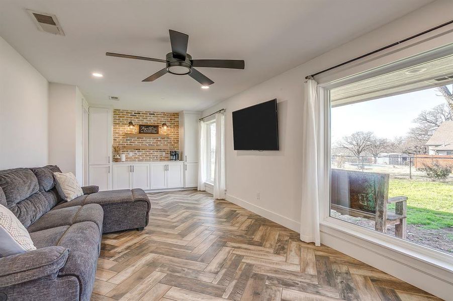 Living area with parquet floors, ceiling fan, and recessed lighting