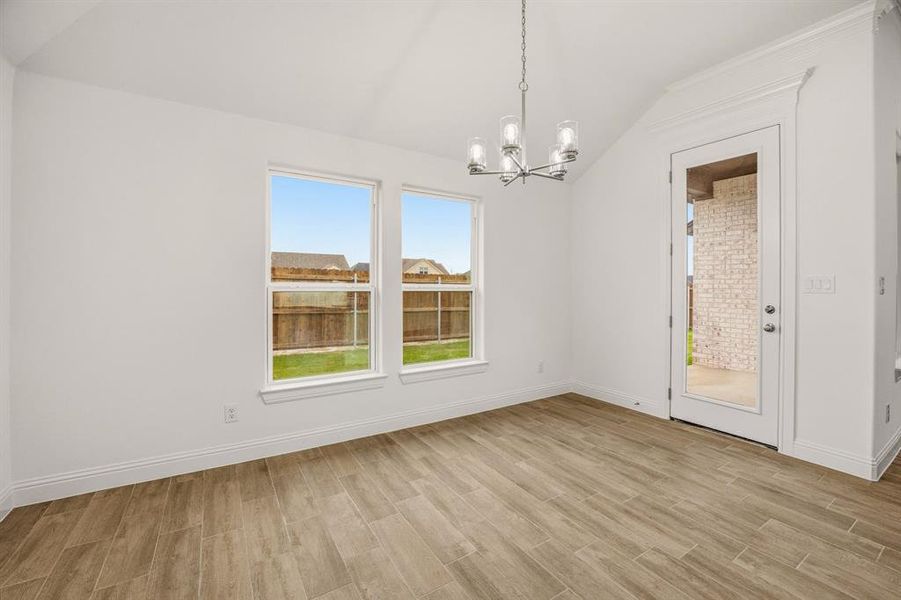 The property features an interior space with light wood-style flooring, white walls, and a vaulted ceiling